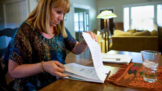 A borrower in default reviews her mortgage paperwork.