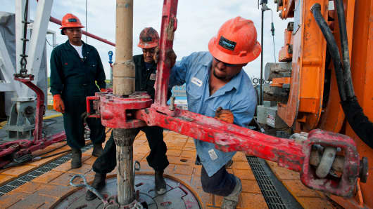 Floor hands make a pipe connection on the drill string on the Orion Perseus drilling rig near Encinal in Webb County, Texas.