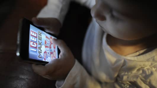 A child plays an app game on an iPod Touch.