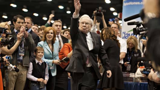 Warren Buffett, chairman of Berkshire Hathaway Inc., tosses a newspaper as he tours the exhibition floor prior to the Berkshire Hathaway shareholders meeting.