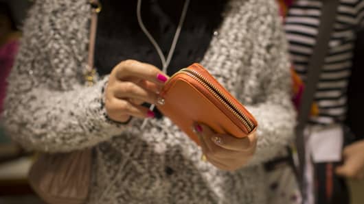 A shopper looks at a Furla SpA wallet inside a Furla store in Hong Kong, China, on Thursday, Feb. 6, 2014.