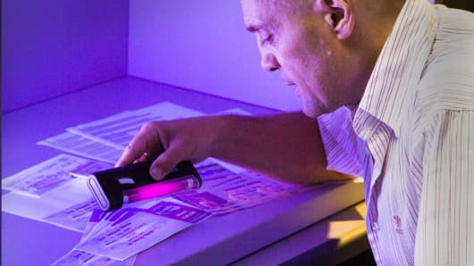 Xerox scientist Reiner Eschbach demonstrates how an ultraviolet light can reveal hidden words and figures.