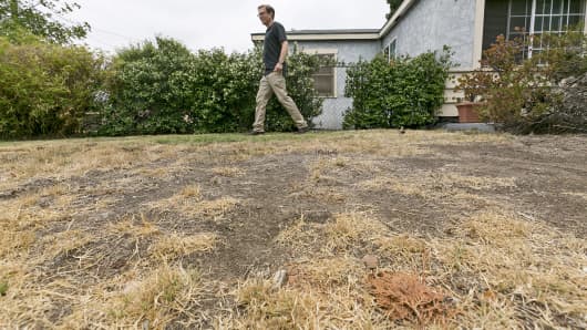 Michael Korte walks on the brown lawn in front of his home in Glendora, Calif.