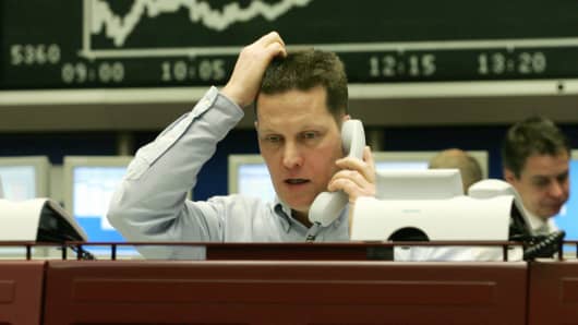 RANKFURT/MAIN, Germany: A trader sitting in front of a chart displaying German share index DAX gestures as he speaks on the phone