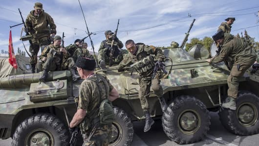 Pro-Russian rebels jump off an armored personnel carrier during a parade in Luhansk, eastern Ukraine.