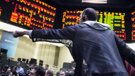 A trader signals orders on the financial floor at the Chicago Board of Trade in Chicago.