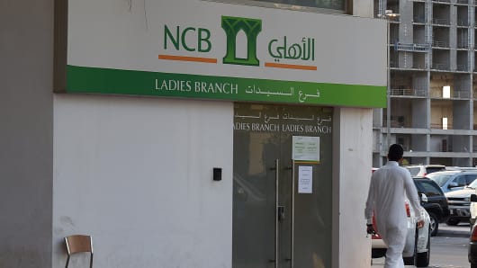 A Saudi man walks in front of a branch of the National Commercial Bank (NCB) in the capital Riyadh.