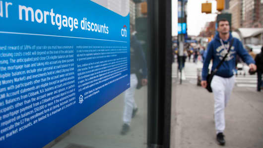 Pedestrians pass a sign advertising mortgages at a Citibank branch in New York.