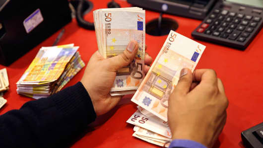 An employee counts fifty euro banknotes at his desk inside a Travelex store, operated by Travelex Holdings in London.