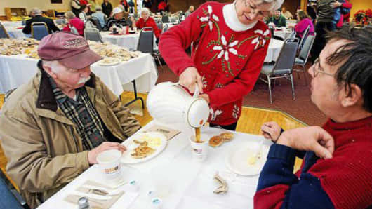 In this December 2011 photo, Connie Howe pours coffee for Ronald Read, left, and Dave Smith during the Charlie Slate Memorial Christmas breakfast at the American Legion in Brattleboro, Vt.
