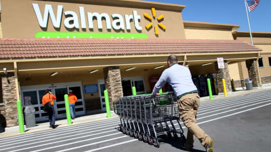 A Wal-Mart employee pushes grocery carts at a store in Miami.