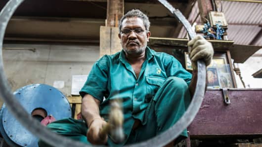 An employee hammers a metal ring an Ishwar Engineering factory in Mumbai, India.