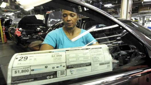 An auto worker places the mileage sticker onto a 2015 Chevrolet Malibu at GM's Fairfax assembly plant in Kansas City, Kansas May 4, 2015.