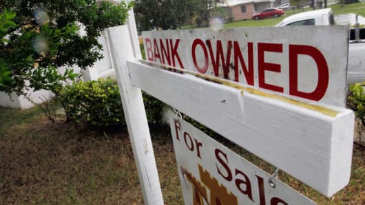 A bank owned sign is seen in front of a foreclosed home.