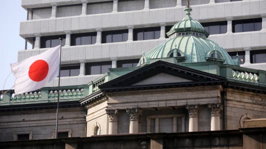 A Japanese flag flies atop the Bank of Japan (BOJ) headquarters in Tokyo, Japan