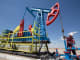 Workers perform maintenance on an oil pumping unit near Atyrau in Kazakhstan.
