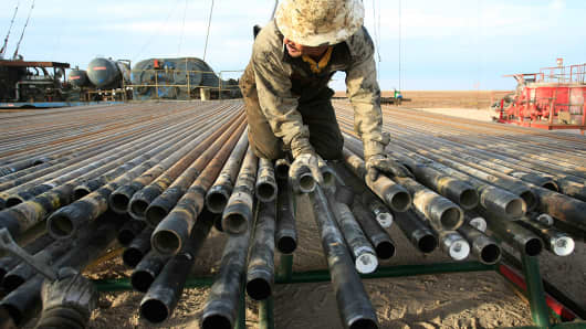 An oil rigger at a Schlumberger field prepares pipes in Midland, Texas.