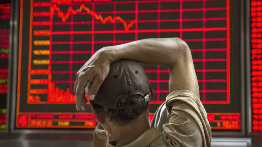 A Chinese day trader watches a stock ticker at a local brokerage house in Beijing, China.