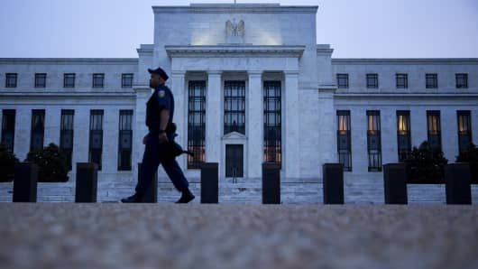 A Federal Reserve police officer walks past the Marriner S. Eccles Federal Reserve building in Washington, D.C.