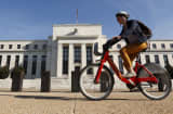 A cyclist passes the Federal Reserve headquarters in Washington.