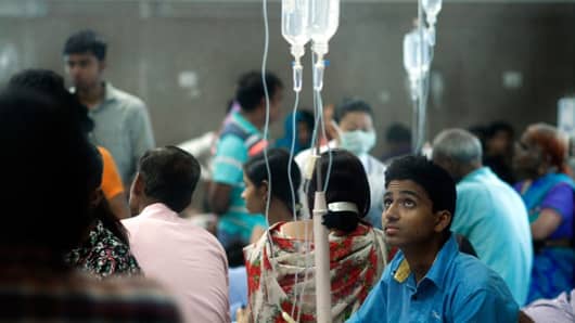 Patients await for routine check-up as they lie under a mosquito net inside a dengue ward of a government hospital, on September 19, 2015 in New Delhi, India.