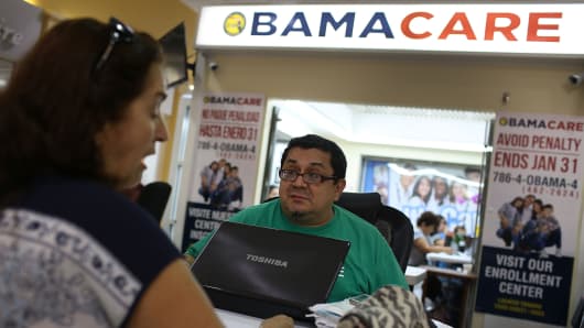 Martha Lucia (L) sits with Rudy Figueroa, an insurance agent from Sunshine Life and Health Advisors, as she picks an insurance plan available in the third year of the Affordable Care Act at a store setup in the Mall of the Americas on November 2, 2015 in Miami, Florida.