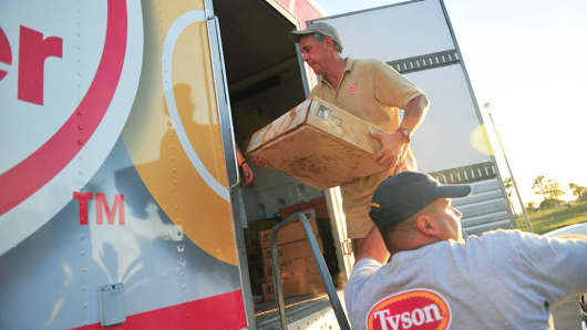 Tyson Food workers handle boxes of food for shipping.