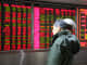 An investor observes stock market at a stock exchange hall in Beijing.