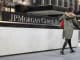 A pedestrian passes a sign in front of JPMorgan Chase headquarters in New York.