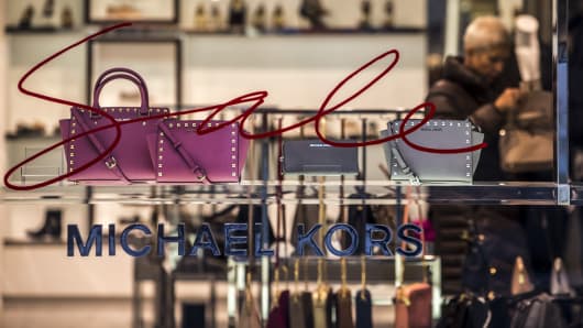 Leather handbags sit on display in the window of a Michael Kors Holdings Ltd. luxury store.