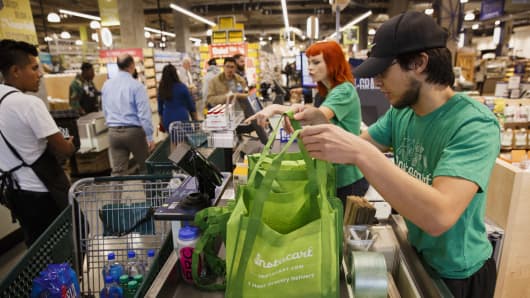 InstaCart employees fulfill orders for delivery at the new Whole Foods Market Inc. store in downtown Los Angeles, California.
