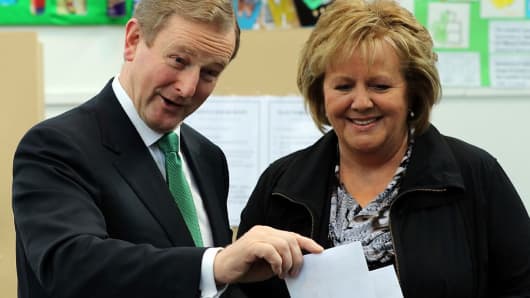 Irish Prime Minister and Fine Gael leader Enda Kenny (L) and his wife Fionnuala vote at St Anthony's Primary School in Castlebar, western Ireland, on February 26, 2016, during a general election.