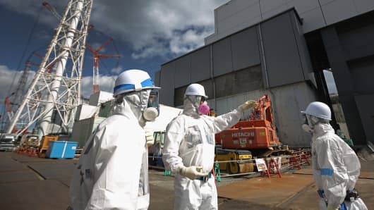 Workers outside Reactor 4 work to decontaminate the Tokyo Electric Power Co.'s Fukushima Daiichi nuclear power plant on Feb. 25, 2016, in Okuma, Japan.