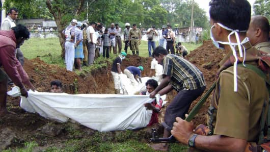 Workers bury the bodies of 41 suspected Tamil Tiger fighters recovered by the government after fighting in the northern district of Vavuniya in January 2009.