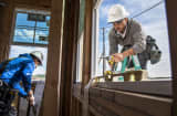 Contractors install a window on a home under construction at the Toll Brothers housing development in San Ramon, California.