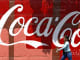 A woman walks past a Coca-Cola advertisement in Caracas, Venezuela.