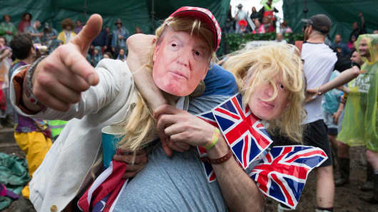 Men dressed as Donald Trump and Boris Johnson prepare to take part in a tomato fight at the Glastonbury Festival 2016 in England.