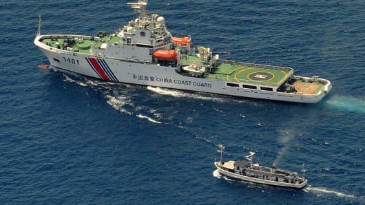 A China Coast Guard ship (top) and a Philippine supply boat engage in a stand off as the Philippine boat attempts to reach the Second Thomas Shoal, a remote South China Sea a reef claimed by both countries, on March 29, 2014.