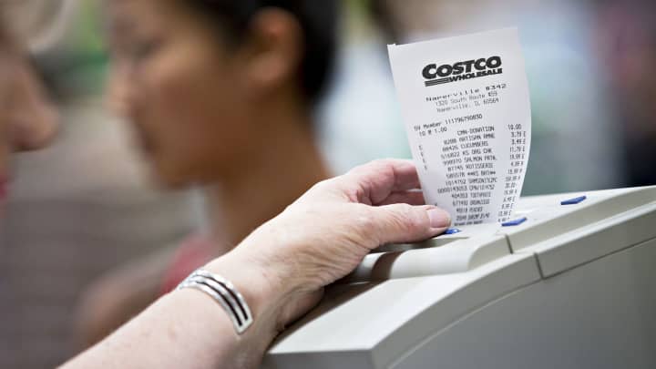 A cashier waits for a receipt to finish printing at a Costco Wholesale store in Naperville, Illinois.