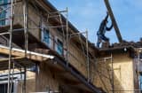 A contractor moves roofing material on a home under construction at the Toll Brothers Cantera at Gale Ranch housing development in San Ramon, California.