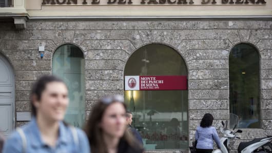 Pedestrians pass by a Banca Monte dei Paschi di Siena SpA bank branch in Milan, Italy, on Tuesday, April 12, 2016.