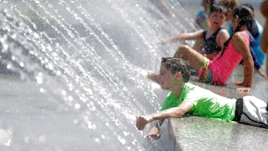 Children play in a fountain during a heat wave