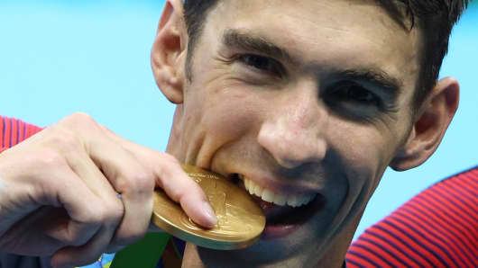 Michael Phelps (USA) of USA poses with his gold medal.