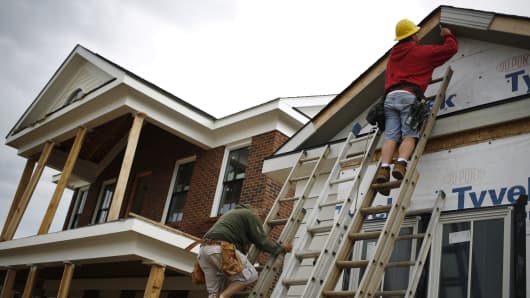 Contractors install siding on a house under construction in the Norton Commons subdivision of Louisville, Kentucky.