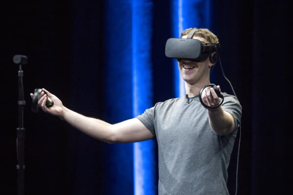 Mark Zuckerberg, chief executive officer and founder of Facebook Inc., demonstrates an Oculus Rift virtual reality (VR) headset and Oculus Touch controllers as the gives a demonstration during the Oculus Connect 3 event in San Jose, California.