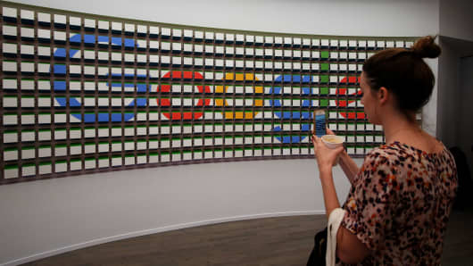 A woman takes pictures of a sign after the opening of Google's pop-up store in New York.