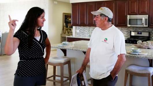 A sales manager gives a tour of a model home to a prospective buyer in Hesperia, California.