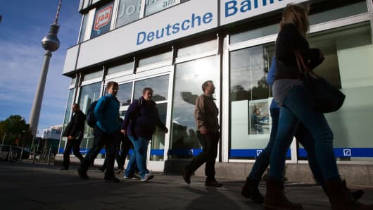 Pedestrians pass a branch of Deutsche Bank in Berlin, Germany.