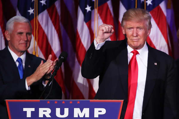 Republican president-elect Donald Trump acknowledges the crowd as Vice president-elect Mike Pence looks on during his election night event at the New York Hilton Midtown in the early morning hours of November 9, 2016 in New York City.