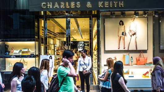 Pedestrians walk past a Charles & Keith store in downtown Kuala Lumpur, Malaysia.